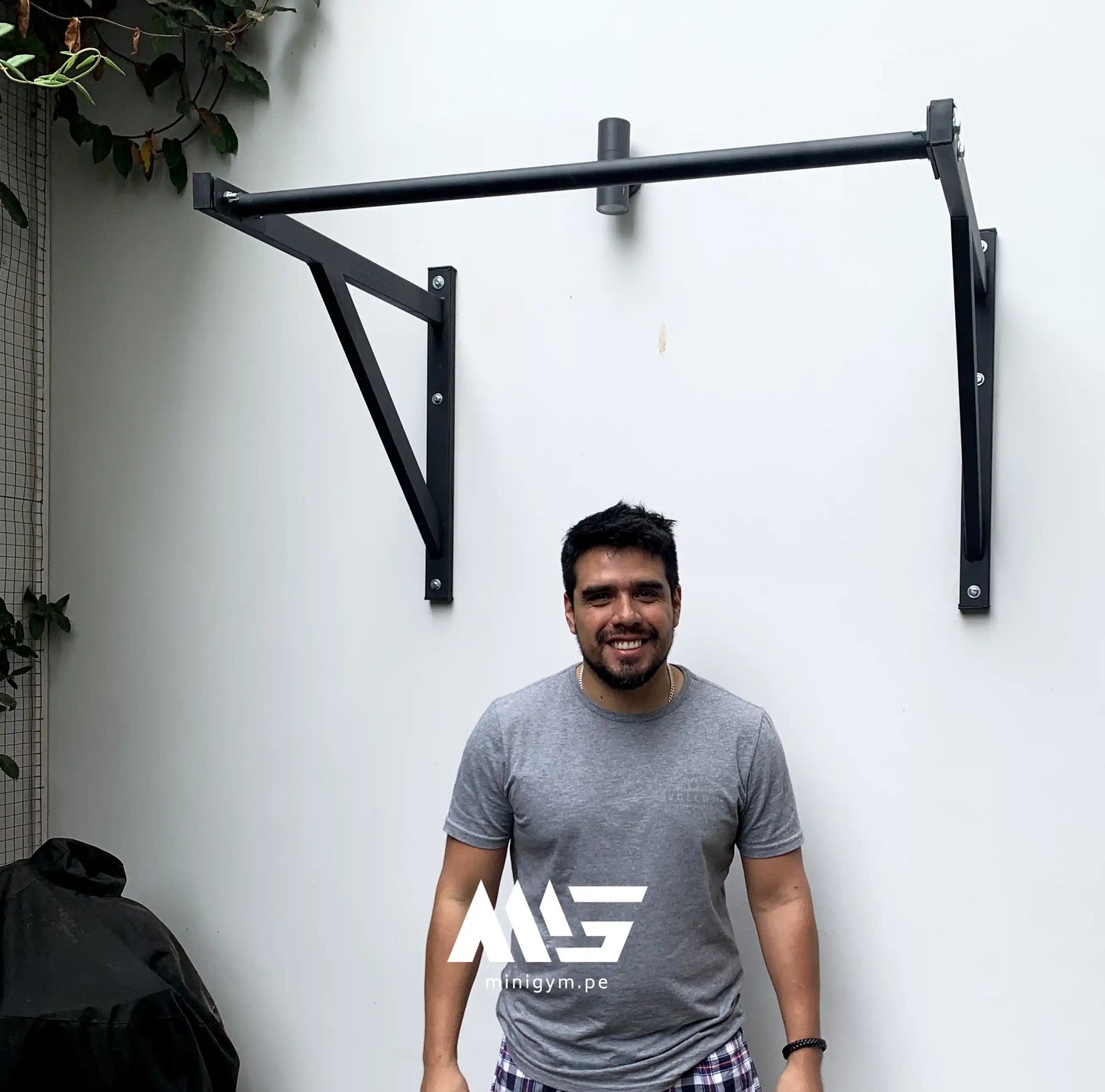 Cliente usando barra de dominadas MiniGym para entrenamiento funcional en casa